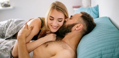 A man and woman laying in bed together.