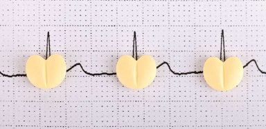 An electrocardiogram with pills on top of the paper.
