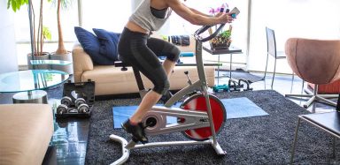 A woman riding on a bike trainer.