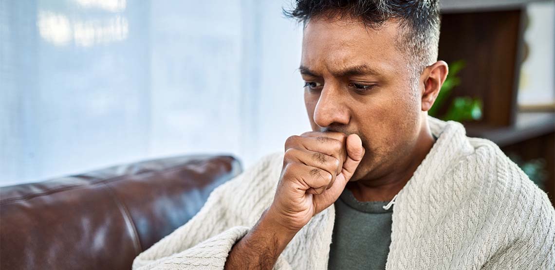 A man coughing into his hand.
