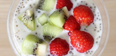 An aerial view of a high fiber smoothie full of chia seeds, kiwi, and strawberries.
